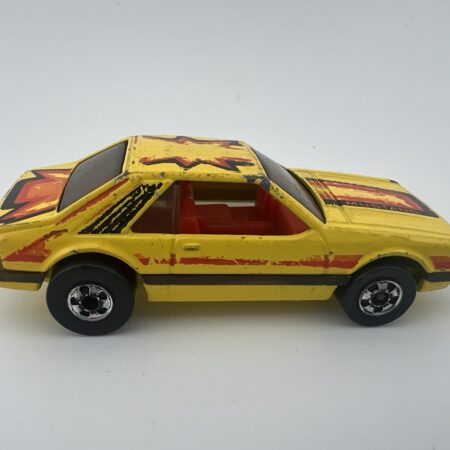 yellow race car diecast vehicle with red graphics side view left profile vintage toy