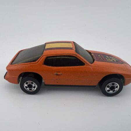 orange hatchback diecast car side view centered vintage compact model