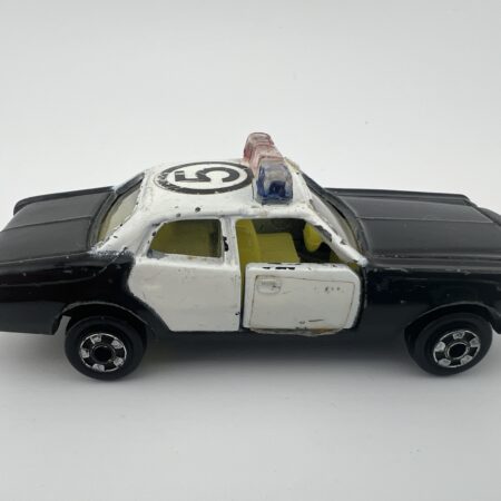 Vintage Zylmex Plymouth P345 police car black and white diecast Hong Kong with roof light bar right side view with wear